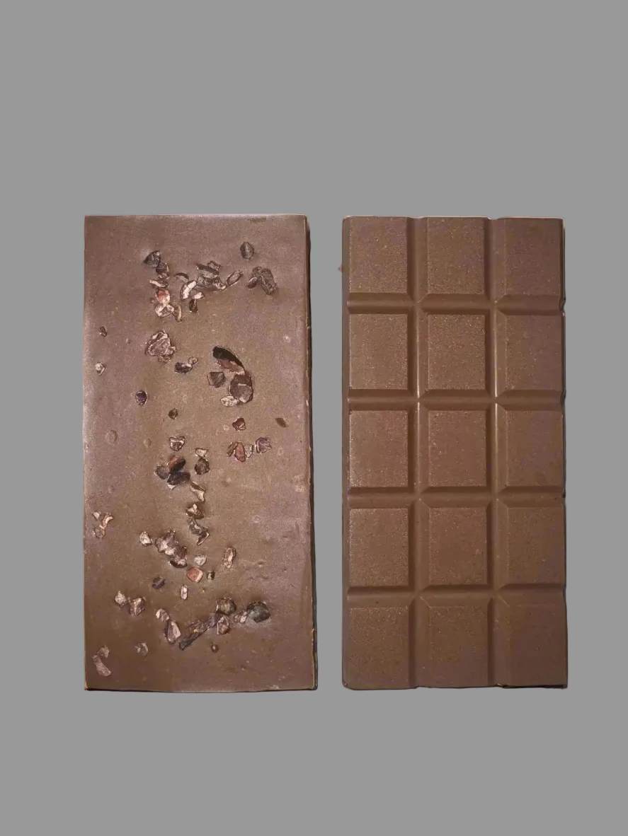 Two chocolate bars, one with visible cocoa nibs and the other in a grid pattern, on a gray background.